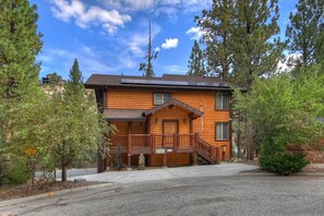 A log cabin with a front porch, a staircase, and a driveway. - Gold Rush Lodge: Exceptional Location in Big Bear's Eagle Mountain Estates! Luxury 5 En Suite Bedrooms! EV Charger! Pet Friendly! (Big Bear Lake)