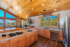 Una cocina amplia con armarios de madera, una isla grande y vistas al exterior a través de las ventanas.