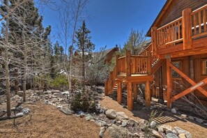 A wooden cabin with a deck and stairs, surrounded by trees and rocks. - Eagle View Lodge by Destination Big Bear: Beautiful Custom-Built Luxury Lakeview Cabin Located in Castle Glen Estates! Spa!Pool Table! Air Conditioning Throughout Home! (Big Bear Lake)
