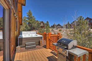 A wooden deck with a hot tub, grill, and outdoor seating area. - Eagle View Lodge by Destination Big Bear: Beautiful Custom-Built Luxury Lakeview Cabin Located in Castle Glen Estates! Spa!Pool Table! Air Conditioning Throughout Home! (Big Bear Lake)