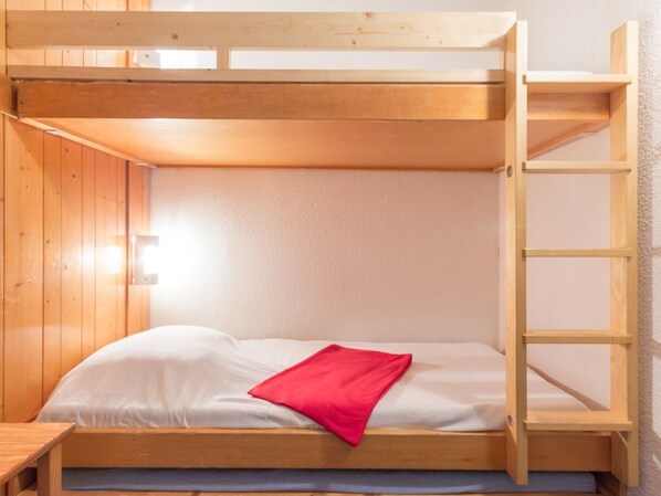 A bunk bed with a wooden ladder, a small table, and a wall-mounted light. - Ski-in/Ski-out Studio with Balcony (Les Arcs 1800)