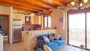 A cozy kitchen with wooden cabinets, a built-in oven, and a stone accent wall. - Villa Petalouda Stunning Villa in Tragaki Zante (Zakynthos)