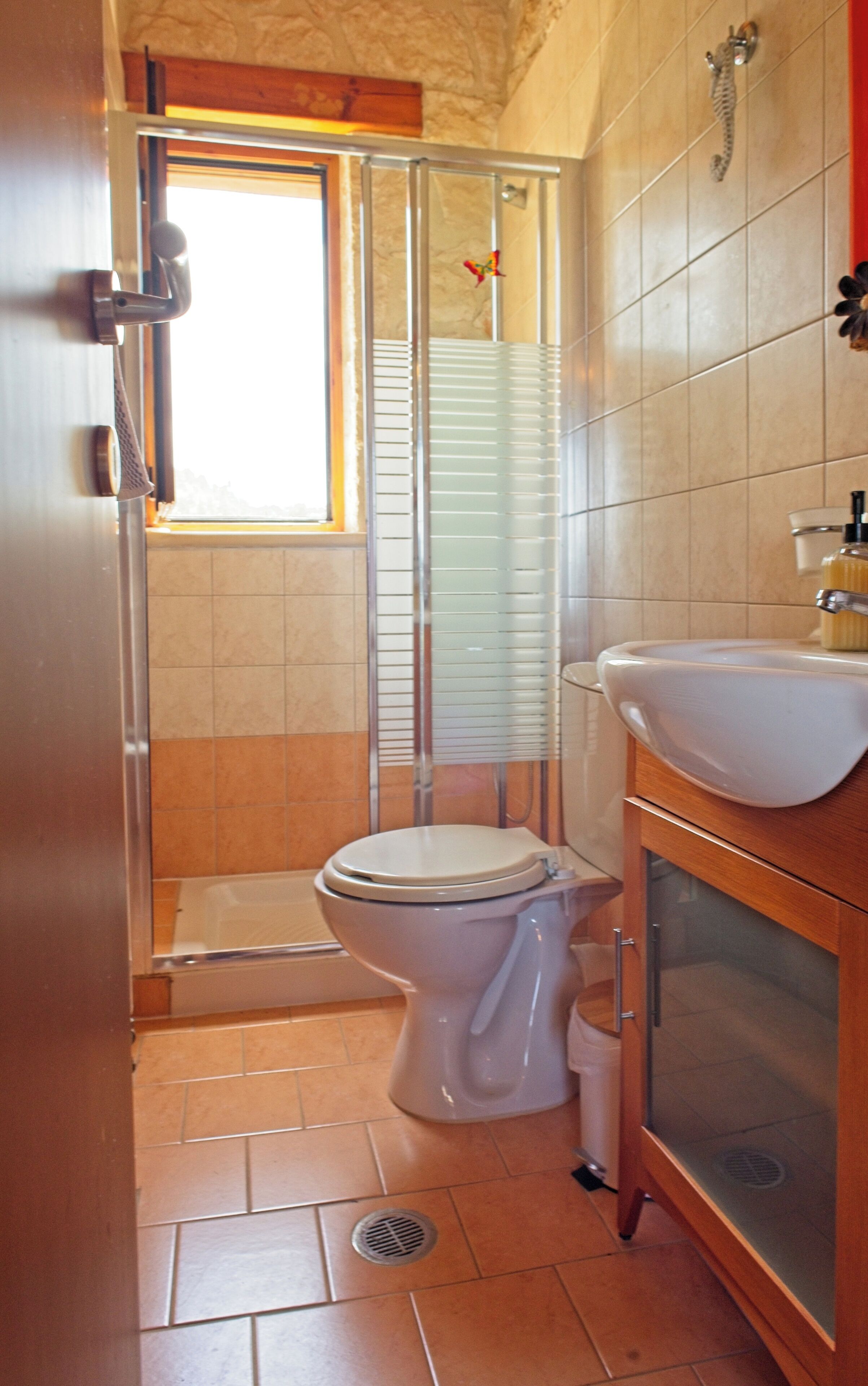 A bathroom with a toilet, sink, and shower.