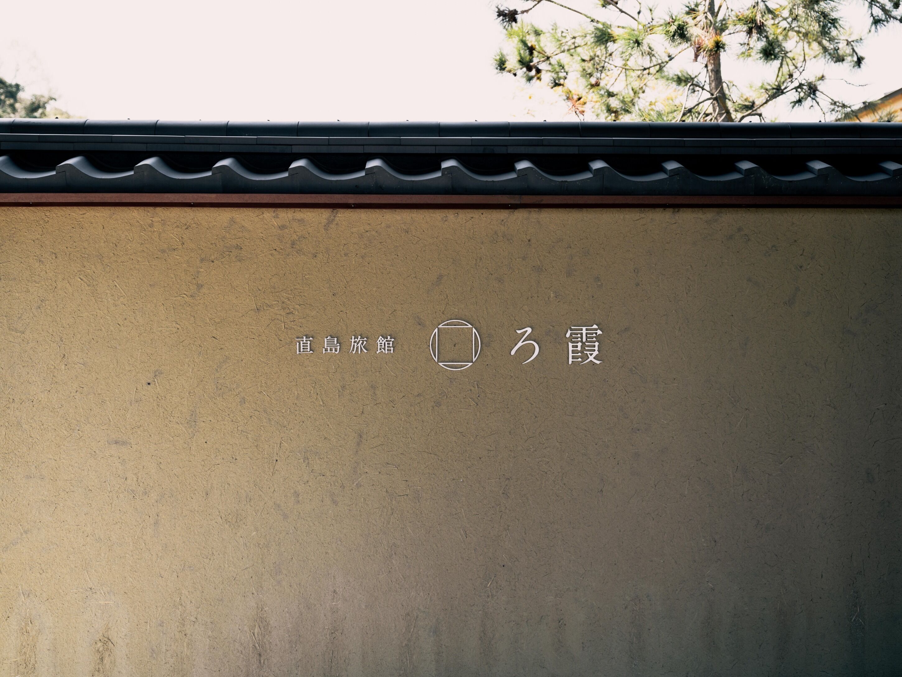 A wall with Japanese characters and a square symbol.