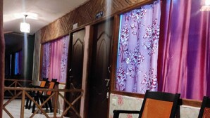 A hotel lobby with a marble floor, wooden paneling, and a row of black chairs with orange backs. - Honey Moon Beach Resort (Port Blair)
