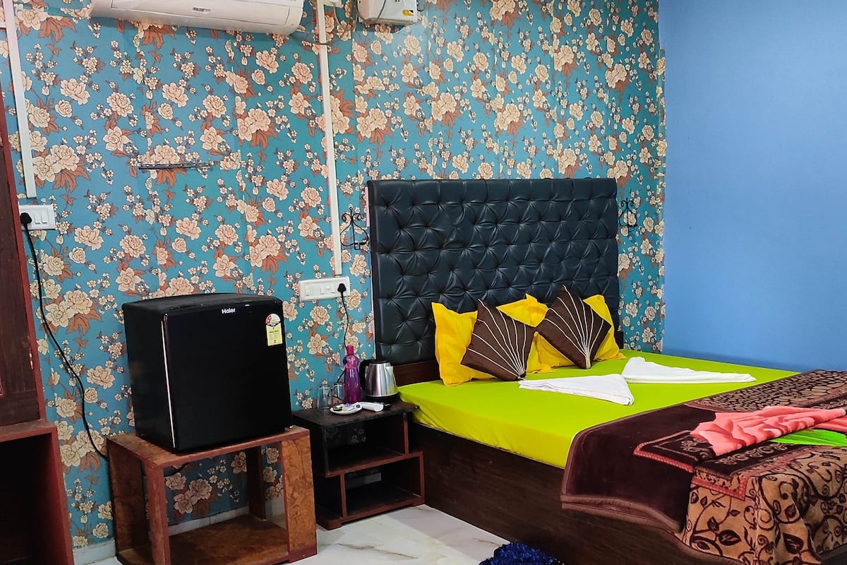 Un dormitorio con cama, televisor, calefactor y aire acondicionado instalado en la pared.