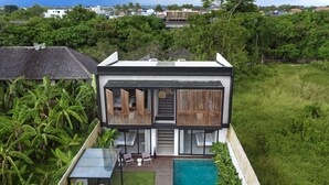 A modern two-story house with a swimming pool, wooden deck, and lush greenery. - RED SUNSET VILLA CANGGU 5 MIN WALK BEACH (Canggu)