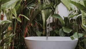 A freestanding bathtub surrounded by lush tropical plants. - RED SUNSET VILLA CANGGU 5 MIN WALK BEACH (Canggu)
