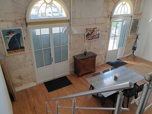 A dining area with a table, chairs, a wooden cabinet, and a poster on the wall.