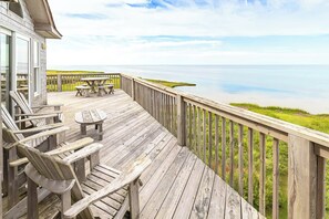 A wooden deck with outdoor seating and a view of the ocean. - Windscape Soundfront in Frisco Incredible Views 400ft to Beach Access! (Frisco)