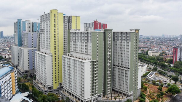 Un immeuble résidentiel de grande hauteur, composé de plusieurs étages, qui présente un mélange de styles architecturaux et de couleurs.