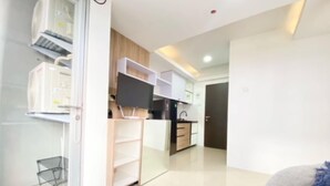 A modern kitchen with white cabinets, a black countertop, and a built-in oven. - Best Deal 2Br At Grand Asia Afrika Apartment (Bandung)