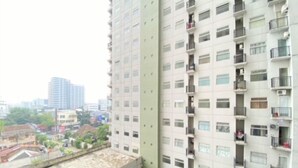 A high-rise building with multiple balconies and a view of the surrounding urban area. - Best Deal 2Br At Grand Asia Afrika Apartment (Bandung)
