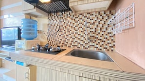 A kitchen with wooden cabinets, a tiled backsplash, a gas stove, and a water dispenser.