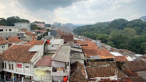 A densely packed urban area with a mix of residential and commercial buildings, featuring traditional tiled roofs and a variety of building materials.