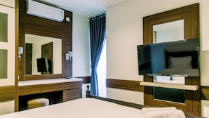 A hotel room with a bed, a TV mounted on the wall, a mirror above the sink, and a window with curtains. - Comfort And Best Choice 2Br At Bintaro Icon Apartment (South Tangerang)