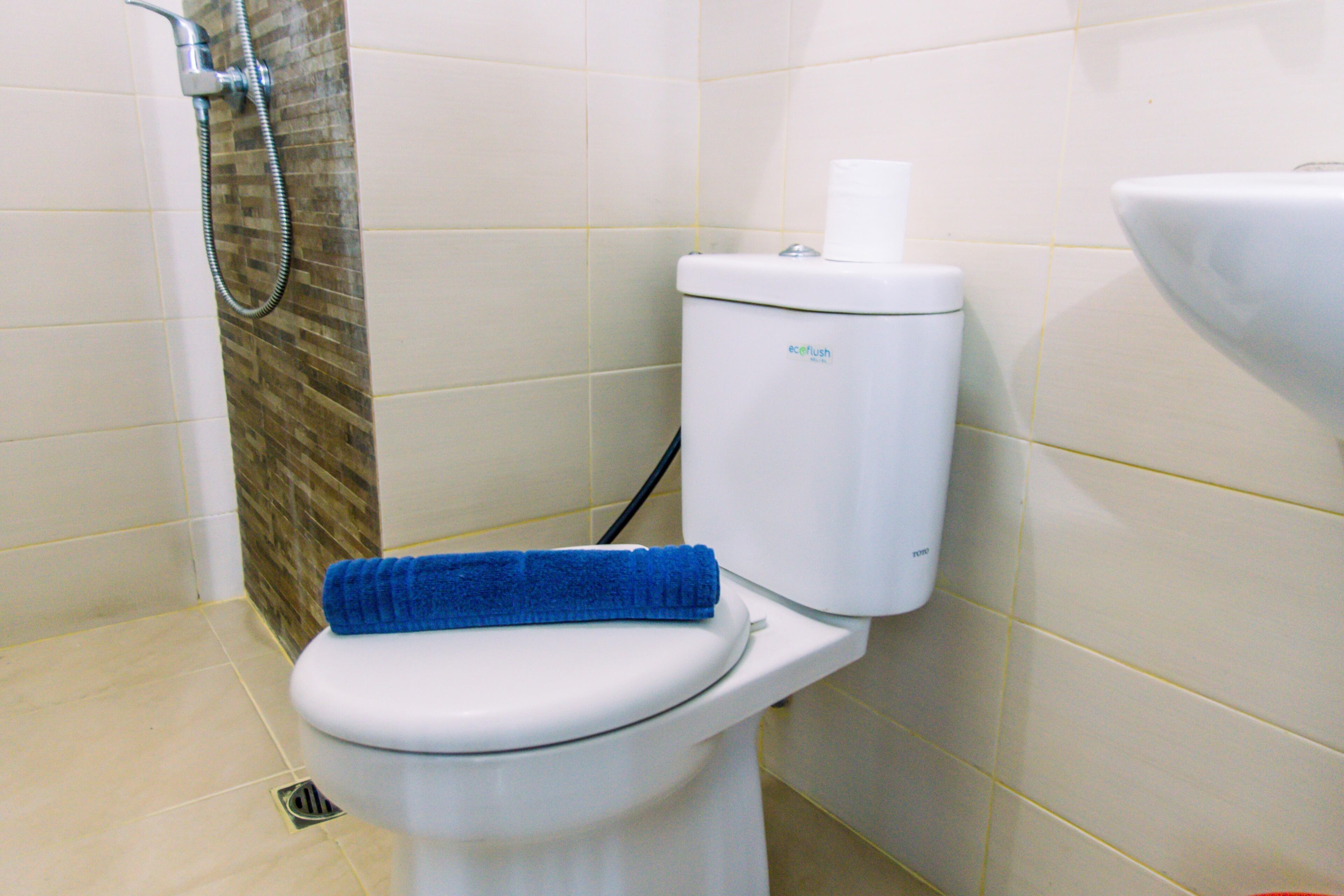 A bathroom with a toilet, a shower, and a sink.