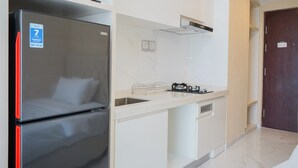 A modern kitchen with a stainless steel refrigerator, a sink, and a stove.