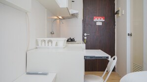 Eine kleine Küchenzeile mit Spüle, Arbeitsfläche und einem Stuhl.