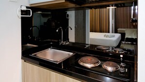 Eine moderne Küche mit schwarzem Arbeitsplatz, Spüle aus Edelstahl und einem Herd mit Töpfen.