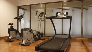 A home gym with a treadmill, elliptical, and stationary bike. - Spacious 2Br Apartment Tamansari Tera Residence (Bandung)
