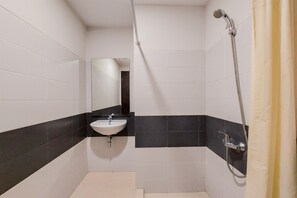 Bathroom features a white sink, chrome faucet, and handheld showerhead, set against a backdrop of alternating black and white tiles.