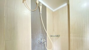 A shower with a glass shelf and a handheld showerhead. - Spacious Studio Furnished Apartment At Gateway Ahmad Yani Cicadas Bandung (Bandung)