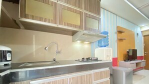 A modern kitchen with a built-in stove, a sink, and a water dispenser. - Spacious Studio Furnished Apartment At Gateway Ahmad Yani Cicadas Bandung (Bandung)