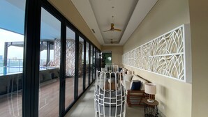 Ein modernes Hotelzimmer mit Balkon, großen Fenstern, einem Deckenventilator und einer dekorativen Wandverkleidung.