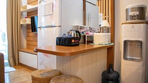 A compact kitchenette with a refrigerator, microwave, and water dispenser. - Nice And Cozy 1Br With Extra Room Apartment At Capitol Park Residence (Jakarta)