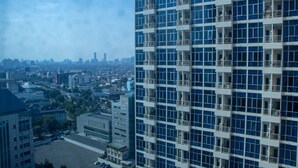 A high-rise building with multiple balconies and a cityscape in the background. - Nice And Cozy 1Br With Extra Room Apartment At Capitol Park Residence (Jakarta)