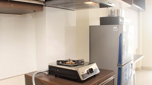 Una cucina con piano cottura integrato, frigorifero e mobili in legno.