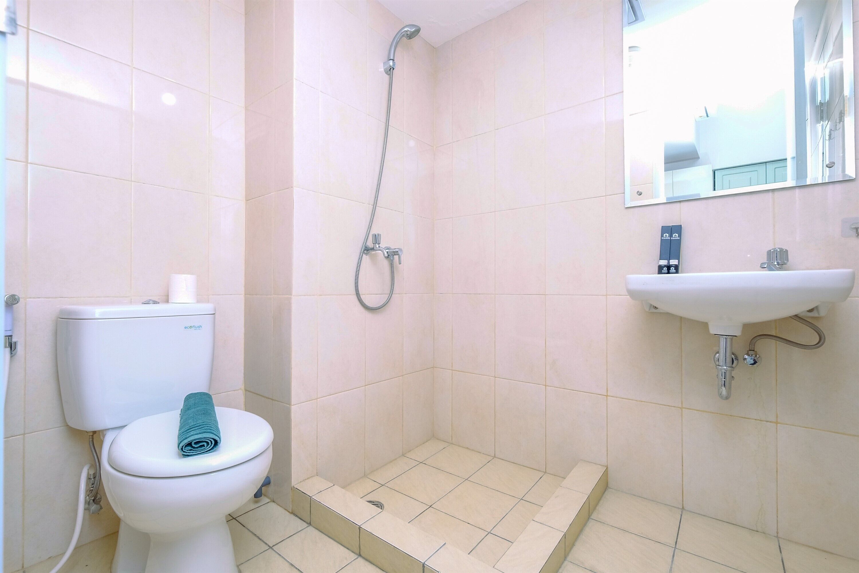 A bathroom with a toilet, shower, and sink.