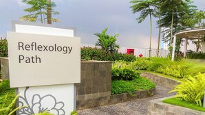 A sign labeled "Reflexology Path" in a landscaped area with greenery and a pathway. - Best Choice And Warm Studio At Springlake Summarecon Bekasi Apartment (Bekasi)