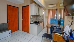 A compact kitchen with a dining area, a small seating area, and a TV. - Cozy And Warm 2Br At Kebagusan City Apartment (Jakarta)