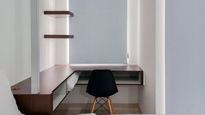 A small, modern room with a desk and chair, a window, and built-in shelves. - Fancy And Nice Studio Apartment At Serpong Garden (Cisauk)