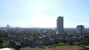 A residential area with a mix of houses and a tall building. - Cozy Living Studio At Taman Melati Surabaya Apartment (Surabaya)