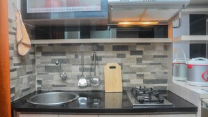 A modern kitchen with a black countertop, stainless steel sink, and a gas stove.