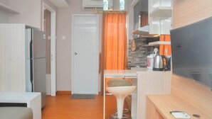 A compact kitchen with a refrigerator, a coffee maker, and a microwave.
