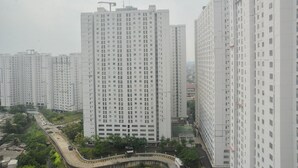 A high-rise residential building with multiple floors, surrounded by other similar structures.