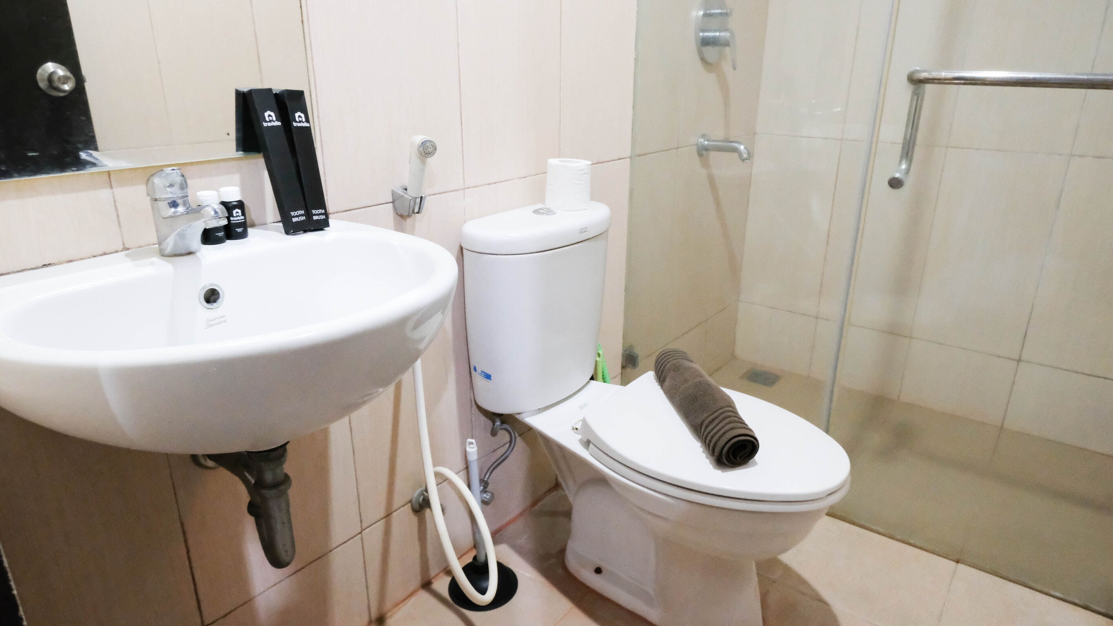 Un baño con lavamanos, inodoro y ducha blancos.