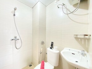 Un baño con ducha, inodoro y lavamanos.