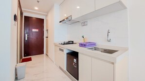 A modern kitchen with white cabinets, a built-in dishwasher, a gas stove, and a stainless steel sink.
