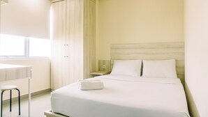 Une chambre d’h ôtel avec un lit, un bureau et une fenêtre.