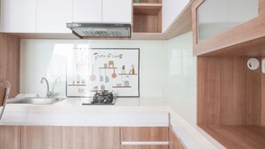 A modern kitchen with white cabinets, a stainless steel sink, and a gas stove.