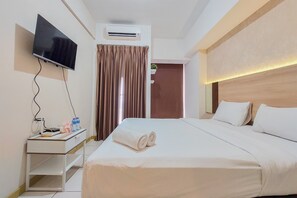 Relax in a serene space with a large bed, flat-screen TV, and air conditioning.