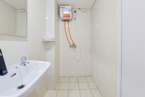 Shower area features a pedestal sink, mirror, and compact showerhead.
