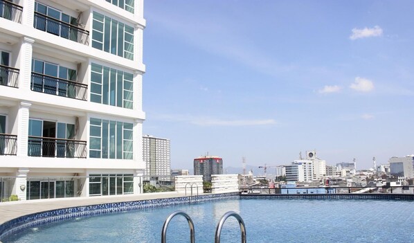 A swimming pool with a cityscape in the background. - Cozy Studio Room At Green Kosambi (Greko) Apartment (Bandung)