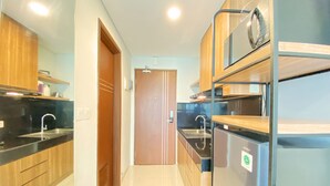 Een moderne keuken met houten kastjes, roestvrijstalen apparatuur en een betegelde vloer.