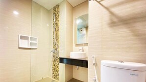Een moderne badkamer met een douchecabine van glas, een wit toilet en een wastafel met een zwart aanrecht.